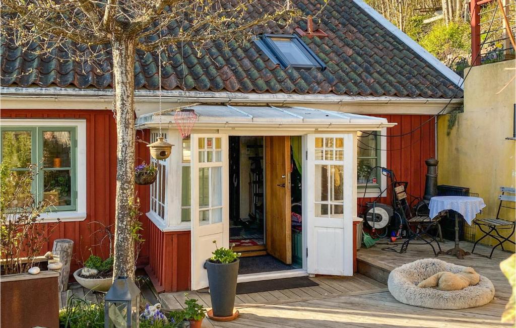 a red house with a white door and a porch at Stunning Home In Vstra Tunhem With Sauna, 2 Bedrooms And Wifi in Västra Tunhem