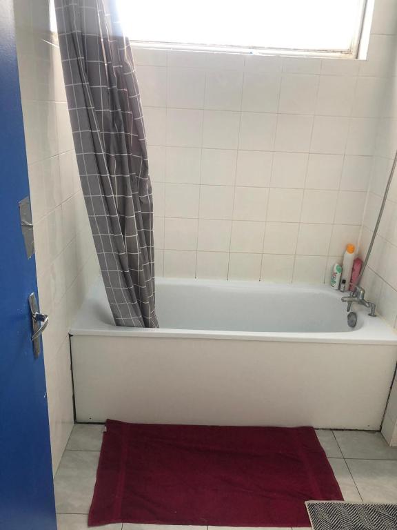 a white bath tub with a shower curtain in a bathroom at A 20 minutes de Paris in Sarcelles