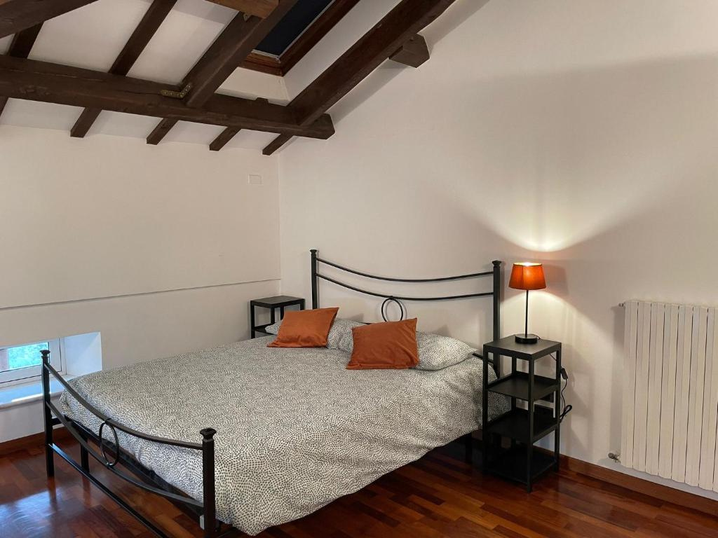 a bedroom with a bed with two orange pillows on it at Villa Livia in Fermo