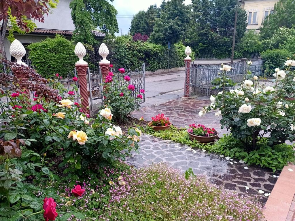 un jardín con flores de colores y una puerta en LILY - STORIE DEL BOSCO -, en San Felice sul Panaro