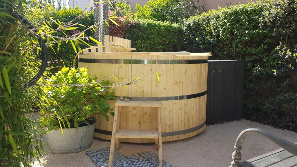 a wooden barrel with a chair in a garden at Studio de charme avec jardin privatif à 10 minutes des plages in Le Beausset