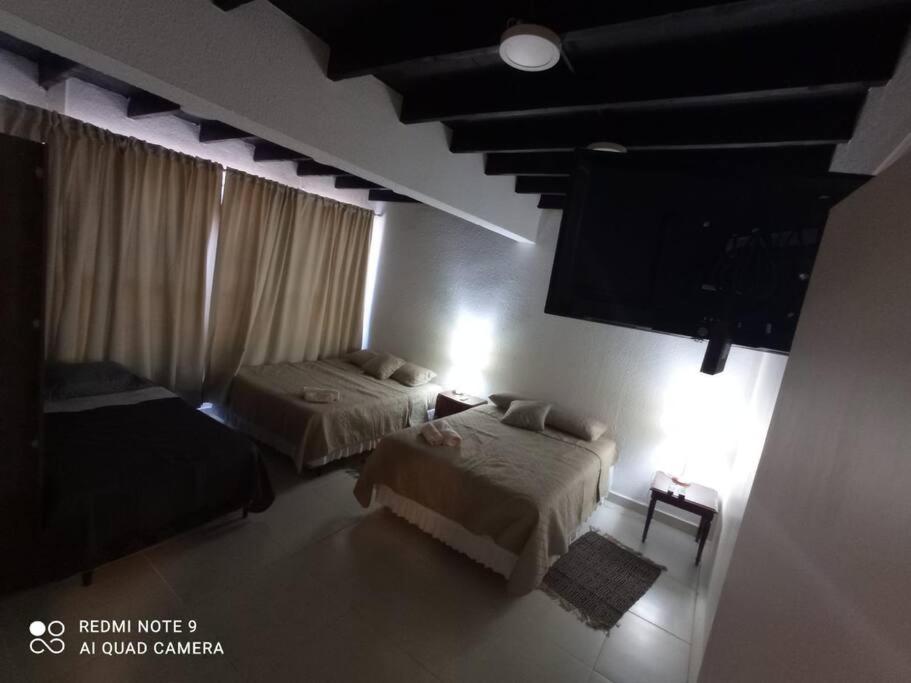 a bedroom with two beds and a flat screen tv at Edificio O'Hara Ap3 in Ciudad del Este