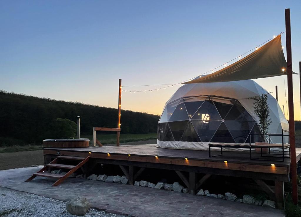 une grande tente sur une terrasse avec une table dans l'établissement Baladome, à Dörgicse