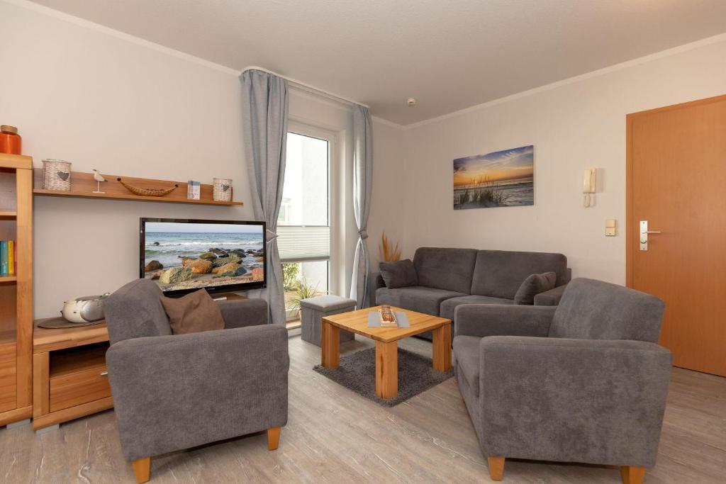 een woonkamer met 2 banken en een flatscreen-tv bij Yachthafenresidenz-Wohnung-6101-818 in Kühlungsborn
