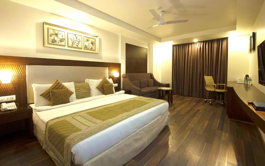 Cette chambre comprend un grand lit et un bureau. dans l'établissement Hotel Le Roi Near New Delhi Railway Station, à New Delhi