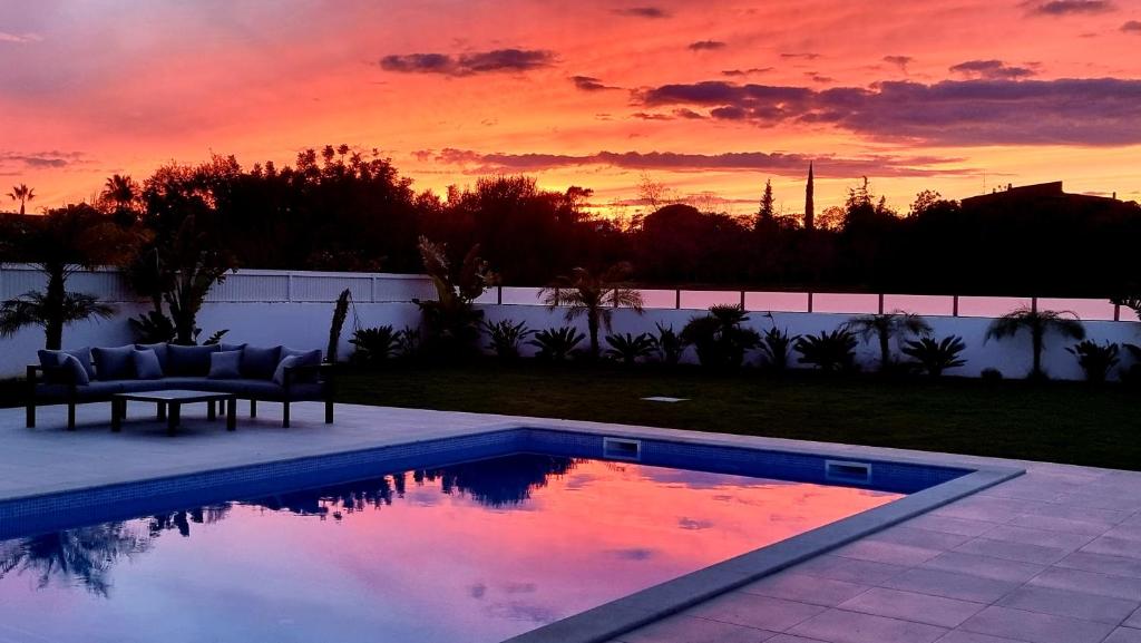 einen Pool mit Sonnenuntergang im Hintergrund in der Unterkunft Villa Sunset in Guia