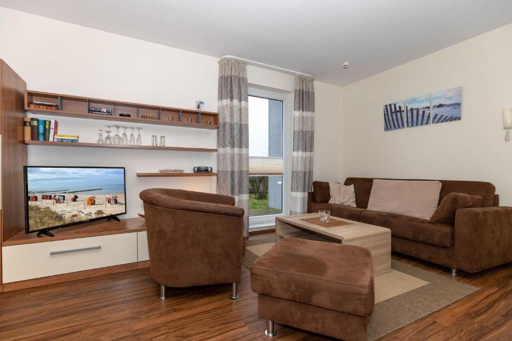a living room with a couch and a flat screen tv at Yachthafenresidenz-Wohnung-8101-845 in Kühlungsborn