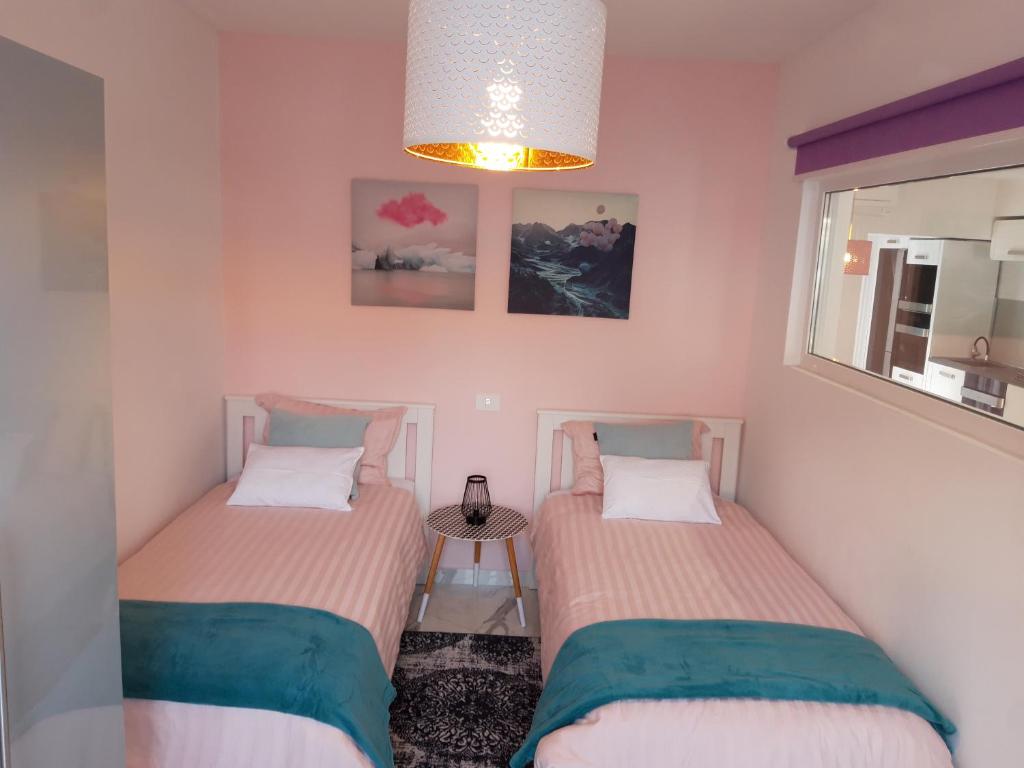 2 camas individuales en una habitación con ventana en Villa Dolce Amaro, en Izola