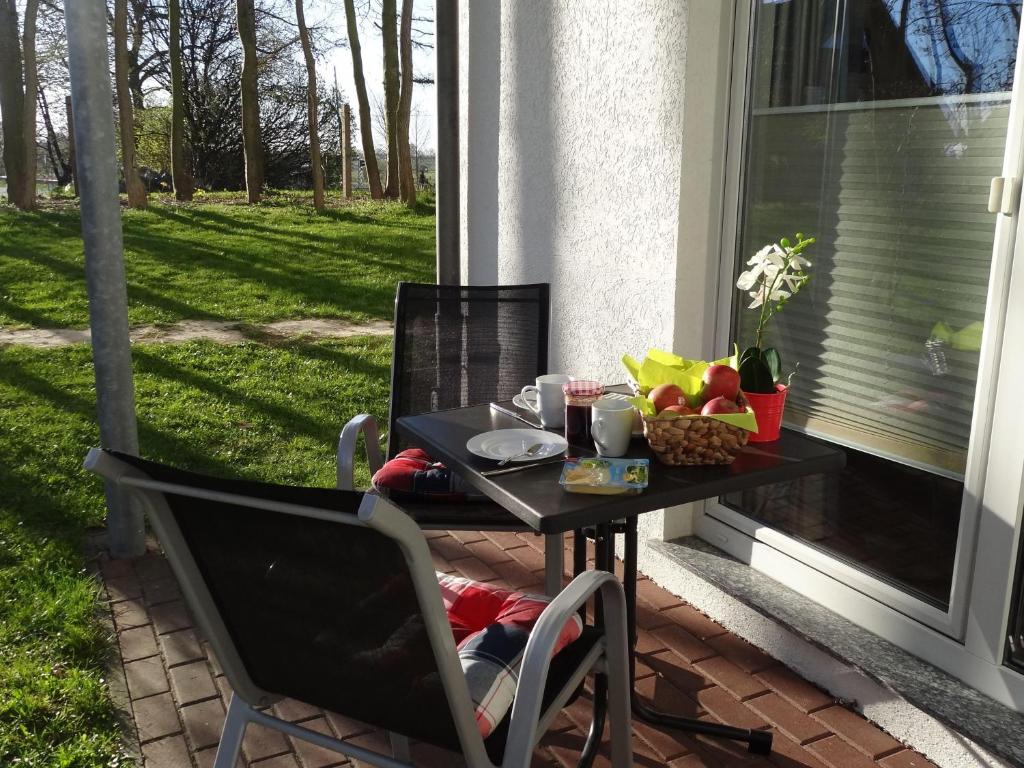 a table and chairs on a porch with a table and fruit at Yachthafenresidenz-Wohnung-8109-847 in Kühlungsborn