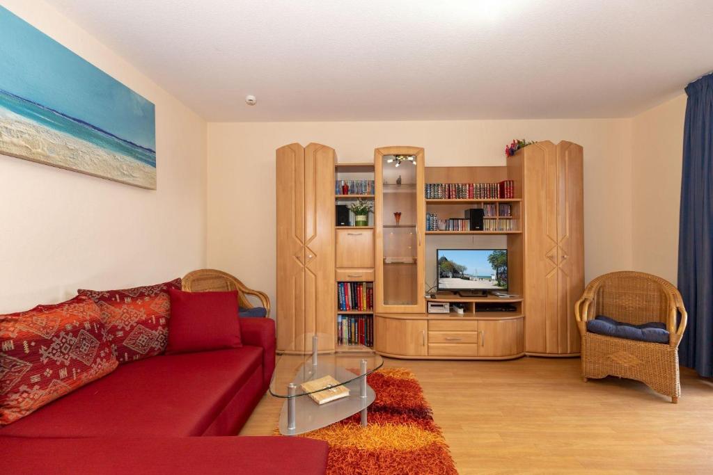 a living room with a red couch and a tv at Yachthafenresidenz-Wohnung-8112-850 in Kühlungsborn
