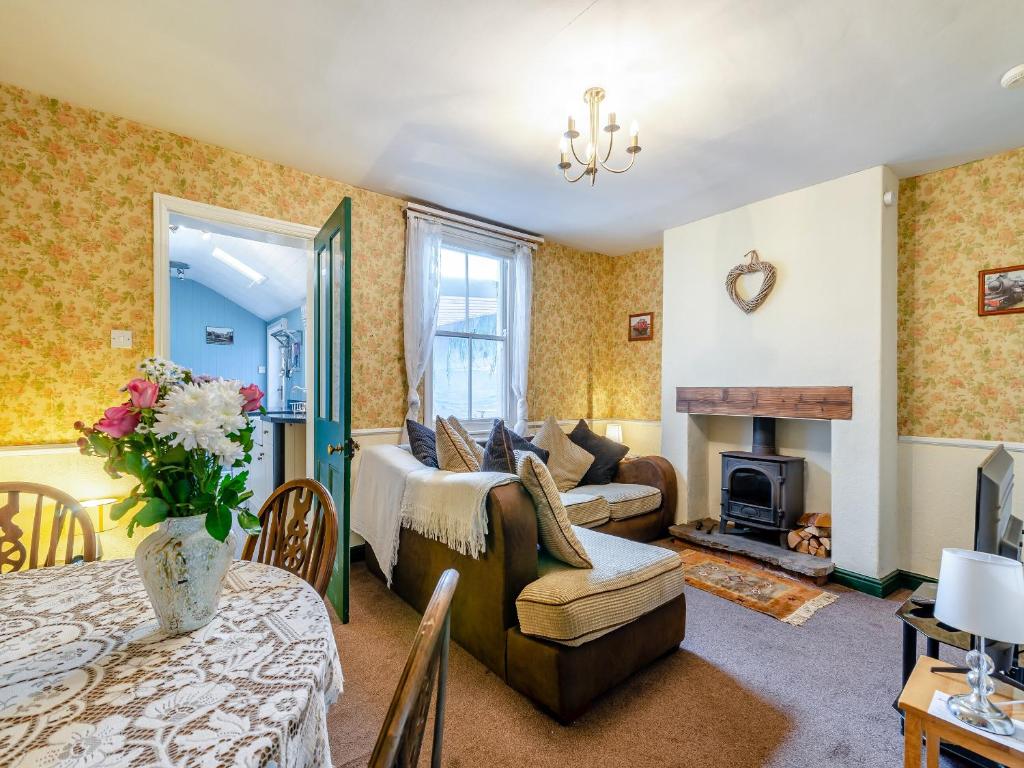 a living room with a couch and a fireplace at Lilac Cottage in Grosmont
