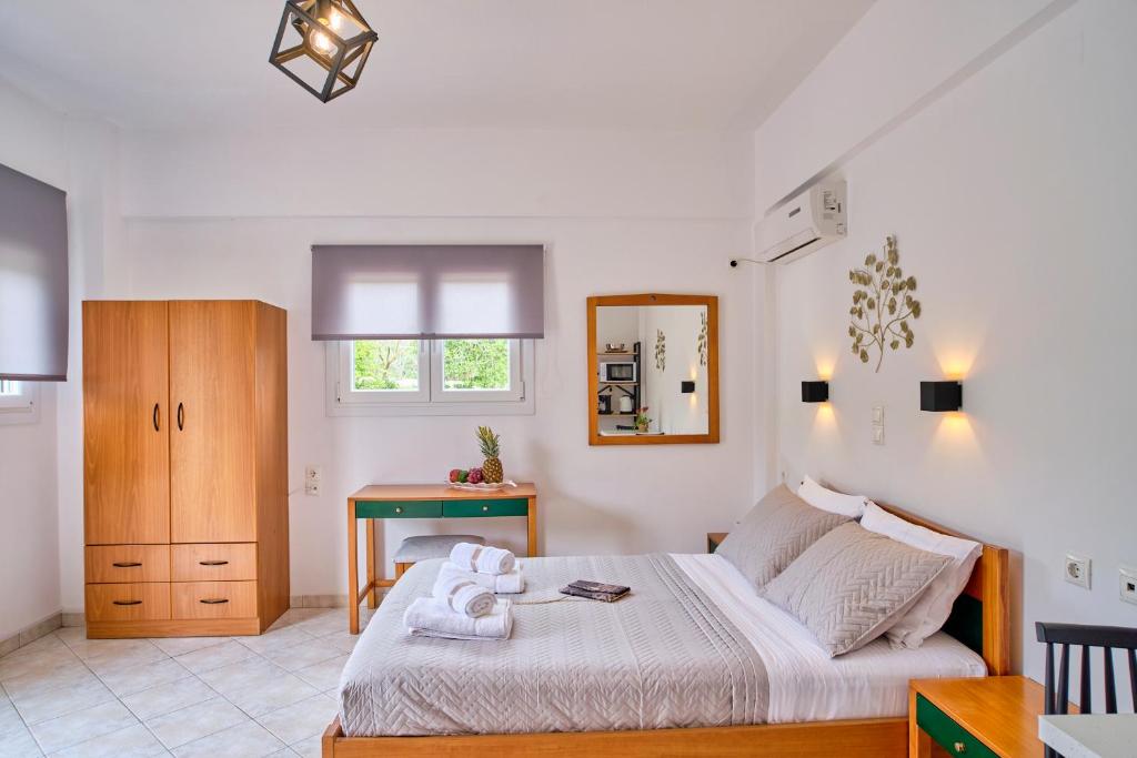 a bedroom with a bed and a desk in it at Logas Beach Studios Peroulades Corfu in Peroulades