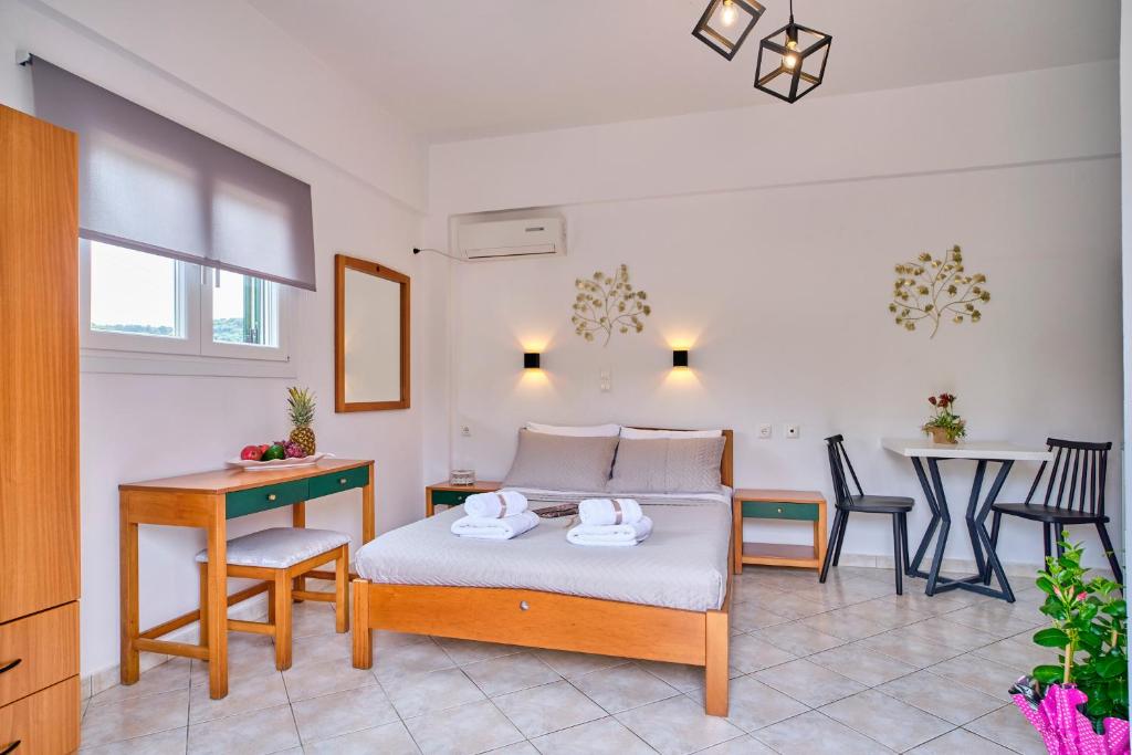 a bedroom with a bed and a table and chairs at Logas Beach Studios Peroulades Corfu in Peroulades