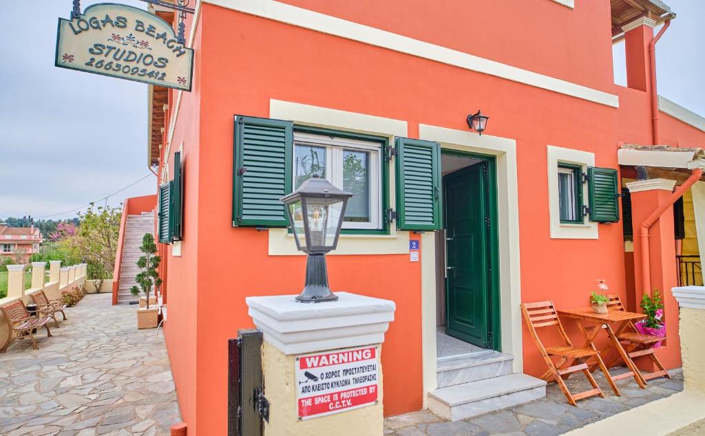 a orange building with a street light in front of it at Logas Beach Studios Peroulades Corfu in Peroulades