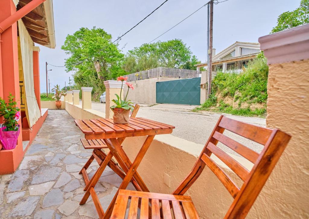 a wooden table and a chair sitting next to a table at Logas Beach Studios Peroulades Corfu in Peroulades