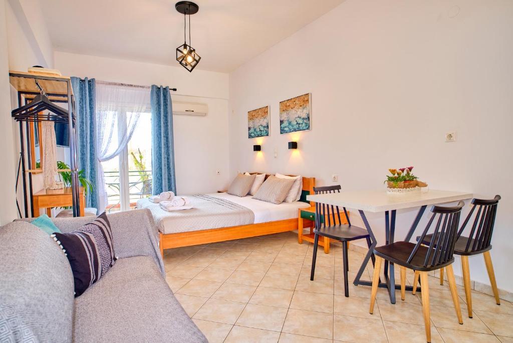 a living room with a bed and a table at Logas Beach Studios Peroulades Corfu in Peroulades
