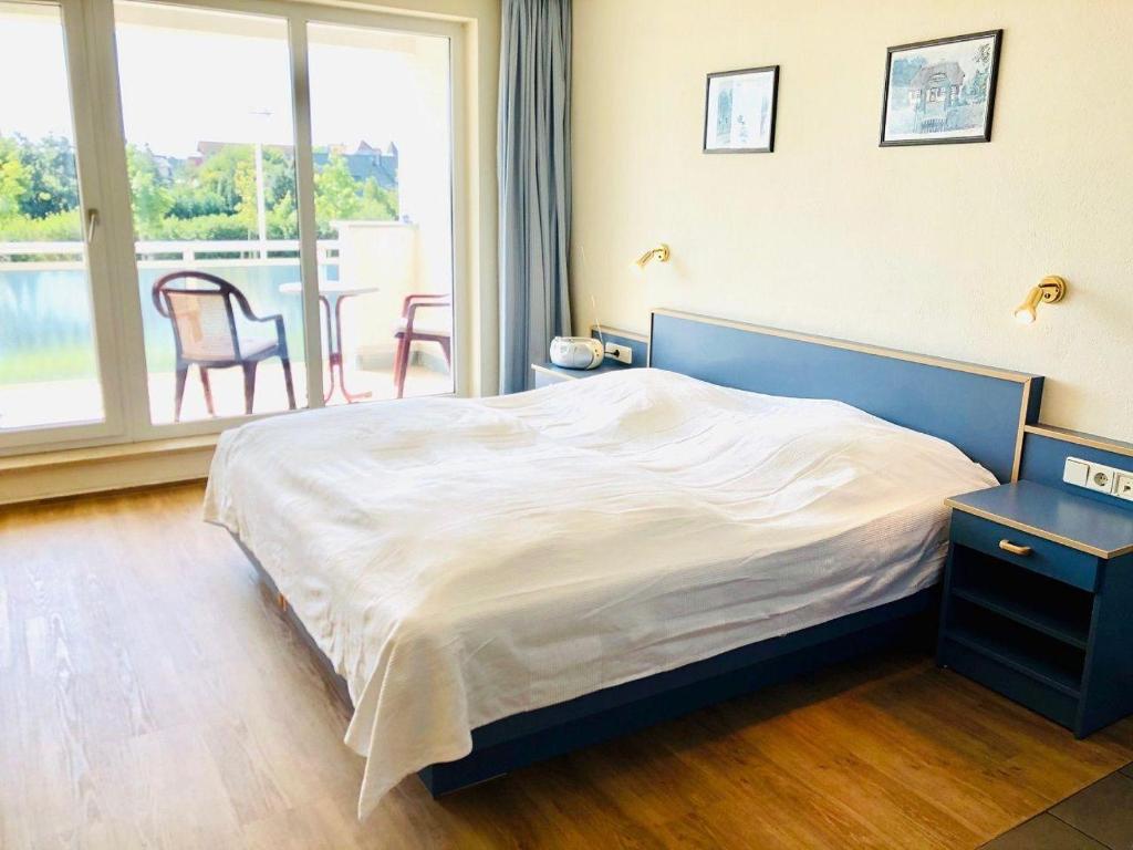 um quarto com uma cama grande e uma janela grande em Yachthafenresidenz-Wohnung-9207-895 em Kühlungsborn