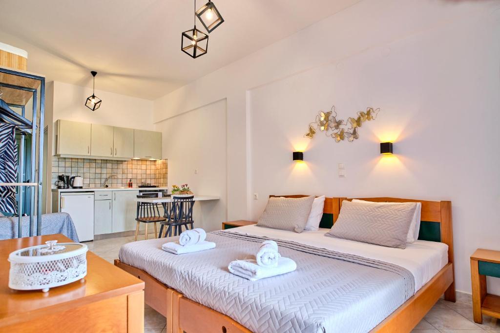 a bedroom with two beds and a kitchen at Logas Beach Studios Peroulades Corfu in Peroulades