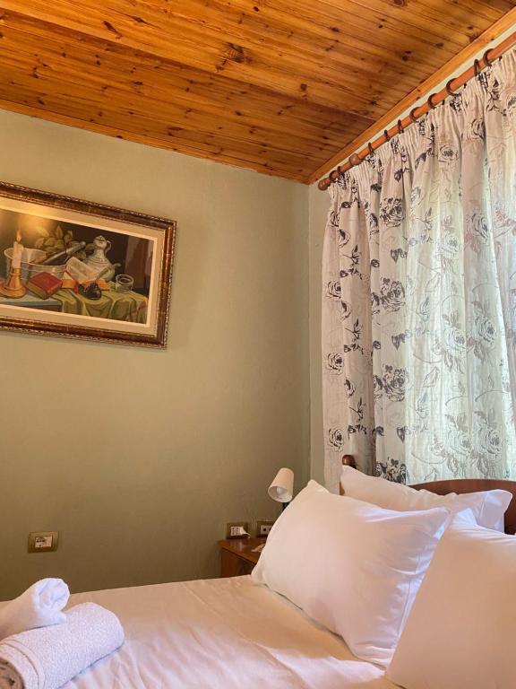 a bedroom with a white bed and a window at Marko's House in Gjirokastër