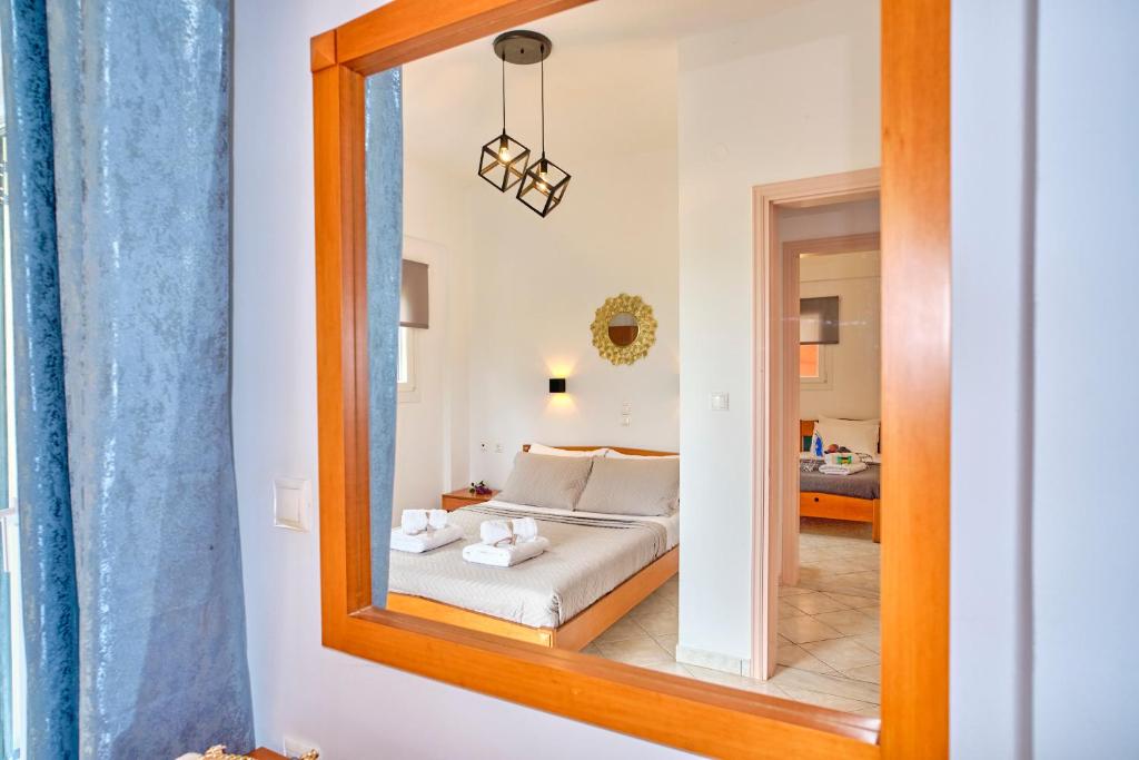 a bedroom with a bed and a mirror at Logas Beach Studios Peroulades Corfu in Peroulades