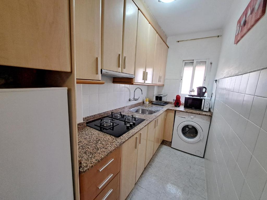 a small kitchen with a sink and a stove at Apartamento acogedor con wifi in Valencia