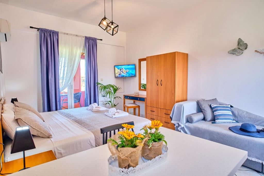 a living room with a bed and a couch at Logas Beach Studios Peroulades Corfu in Peroulades