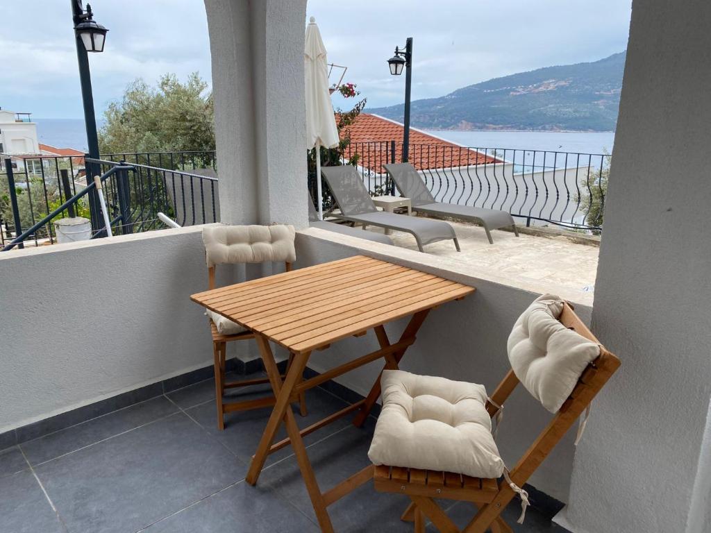 balcón con mesa y sillas de madera en Flat with Shared Pool and Garden in Kalkan Antalya, en Kalkan