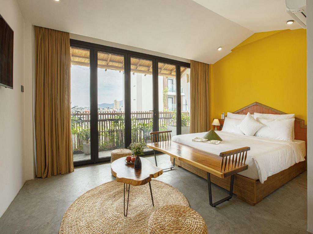 a bedroom with a bed and a large window at TA Danang Boutique Hotel in Da Nang