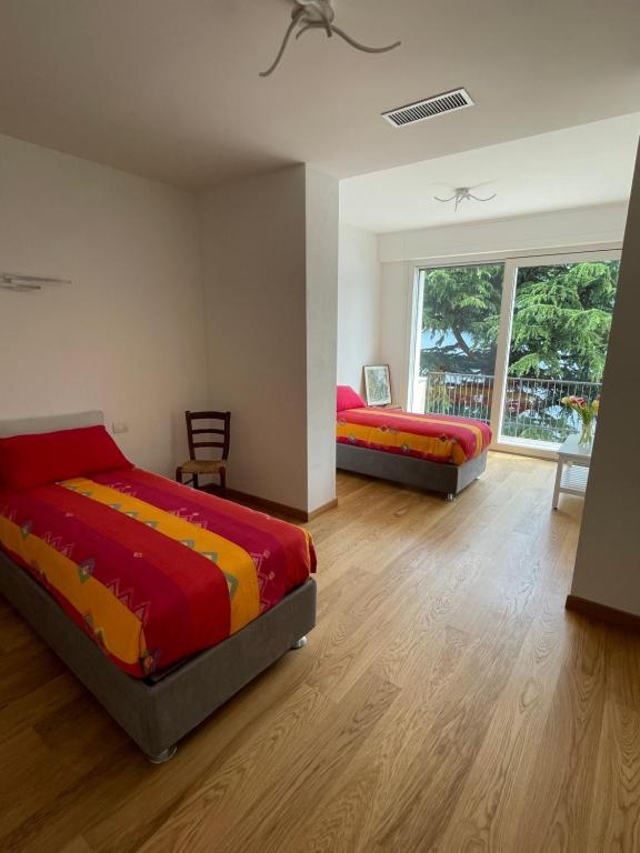 een slaapkamer met 2 bedden en een groot raam bij Appartamento Riviera in Cremia