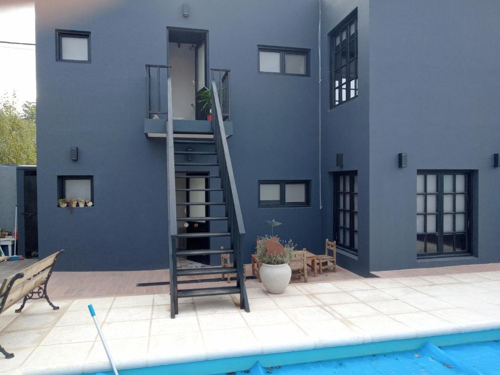 um edifício azul com uma escada ao lado de uma piscina em Apart Lo de Jose em Tandil