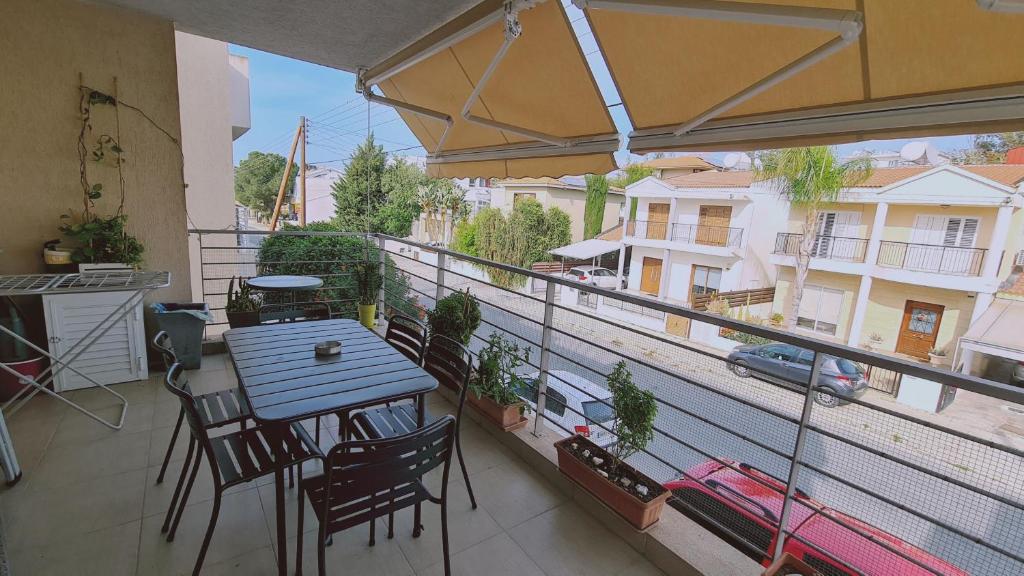 een balkon met een tafel en stoelen en een parasol bij STAY Serenity Apartment in Yukarı Lakatamya