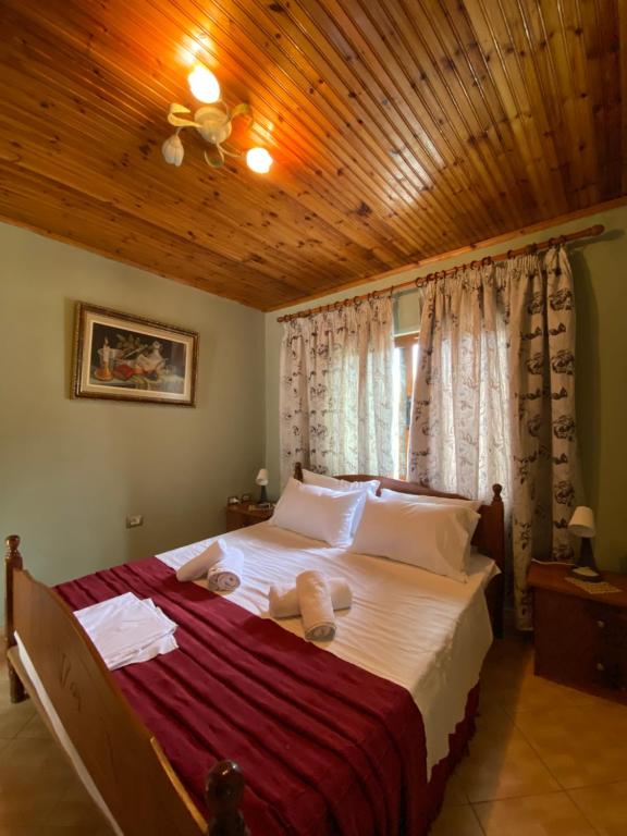 a bedroom with a large bed with a wooden ceiling at Marko's House in Gjirokastër