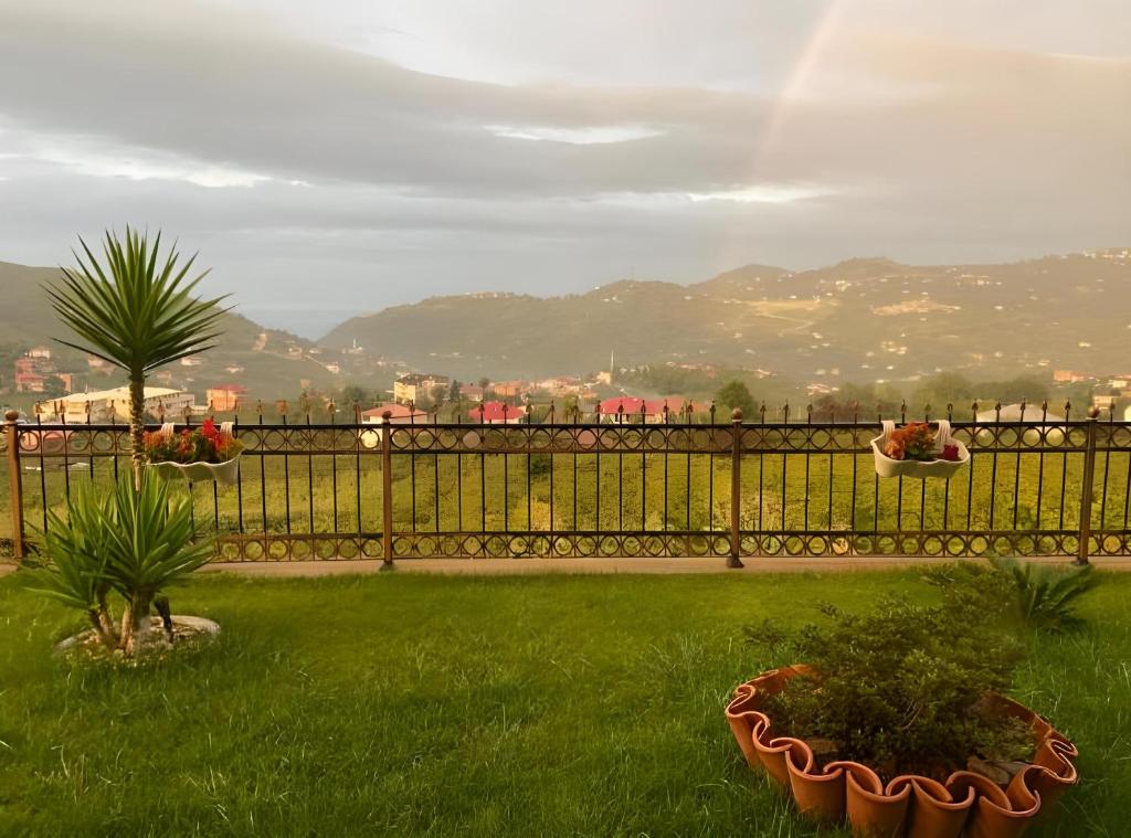 a fence with two potted plants in a yard at Villa Nature in Trabzon