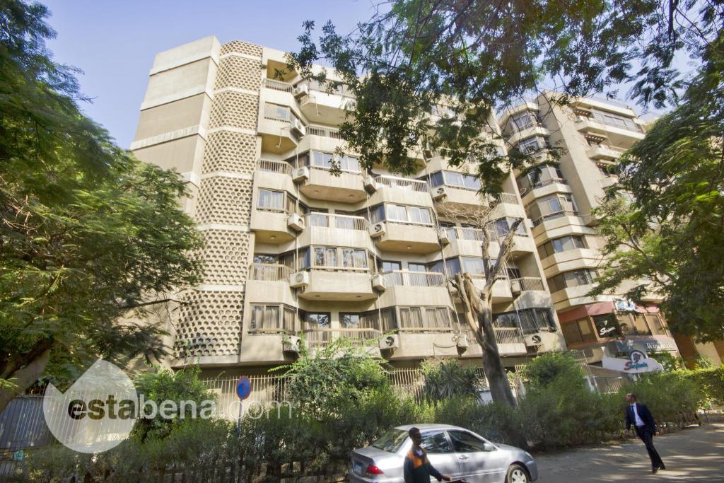 un edificio con un coche aparcado delante de él en Maadi International Center Apartments, en El Cairo