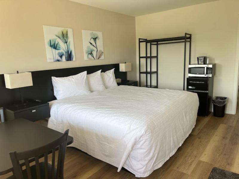 Un dormitorio con una gran cama blanca y una mesa en Richland Inn and Suites en Richland