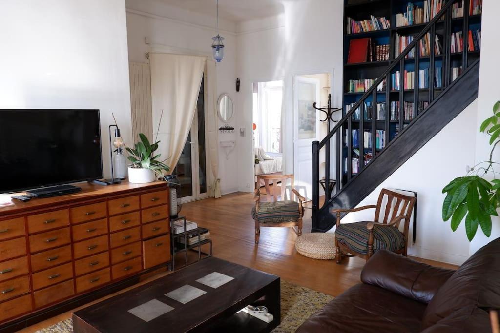 ein Wohnzimmer mit einem Sofa und einem TV auf einer Kommode in der Unterkunft Spacieux T4 tout confort quartier Périer terrasse et vue in Marseille
