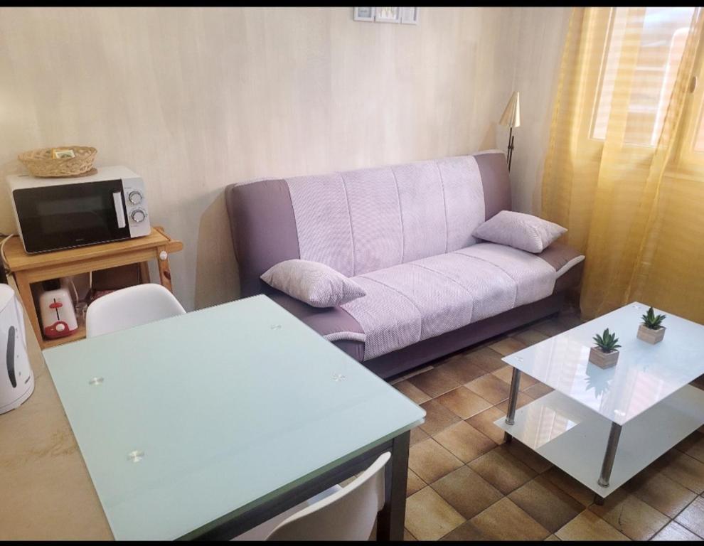 a living room with a couch and a table at Studio proche de la mer in Calvi