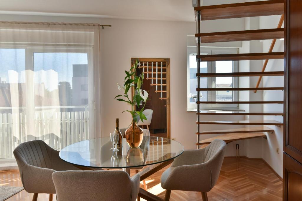 a dining room with a glass table and chairs at APARTMENT MEMORY in Zadar