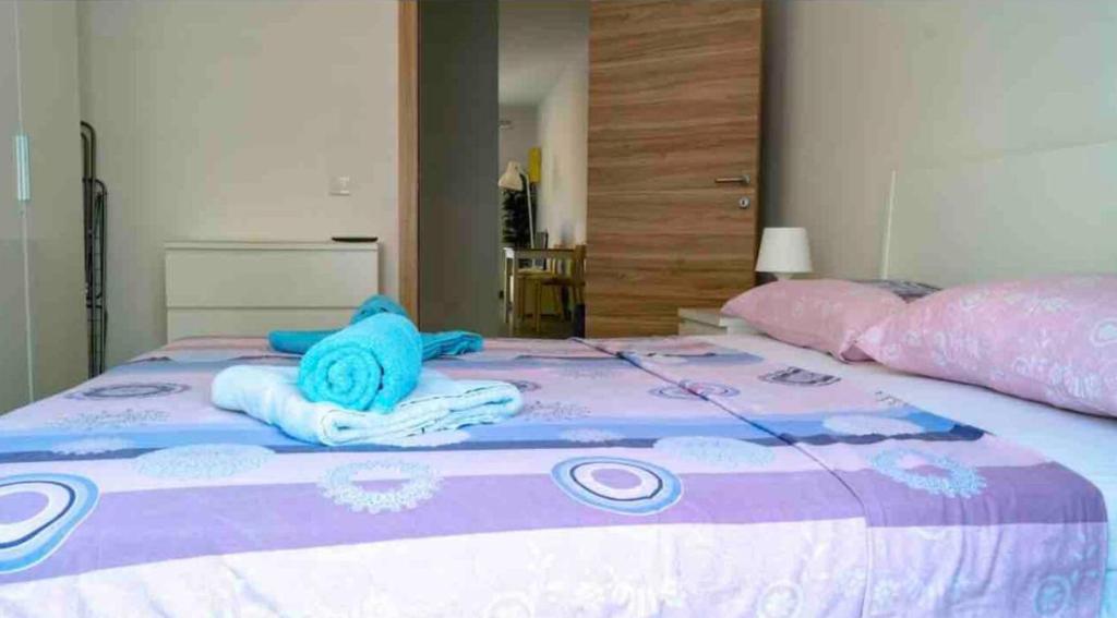 Una cama con un peluche azul encima. en Nicely furnished 1 bedroom apartment in Gzira, en Il-Gżira