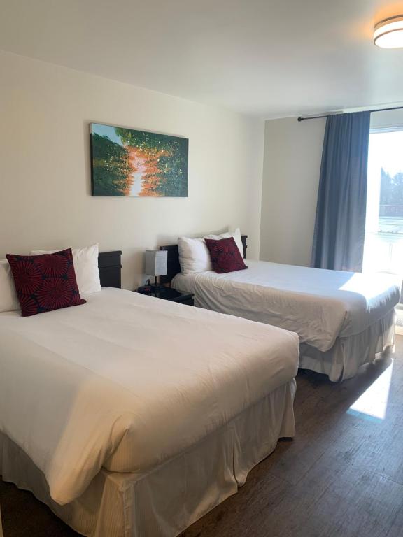 um quarto de hotel com duas camas e uma janela em Nor Villa Hotel em Winnipeg