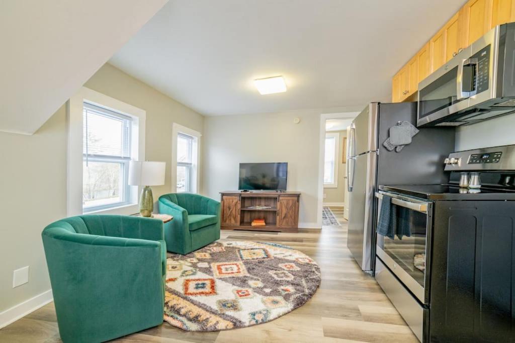 a kitchen with two green chairs and a living room at 2 beds, trailer parking, direct snow & ATV trail access in Gorham