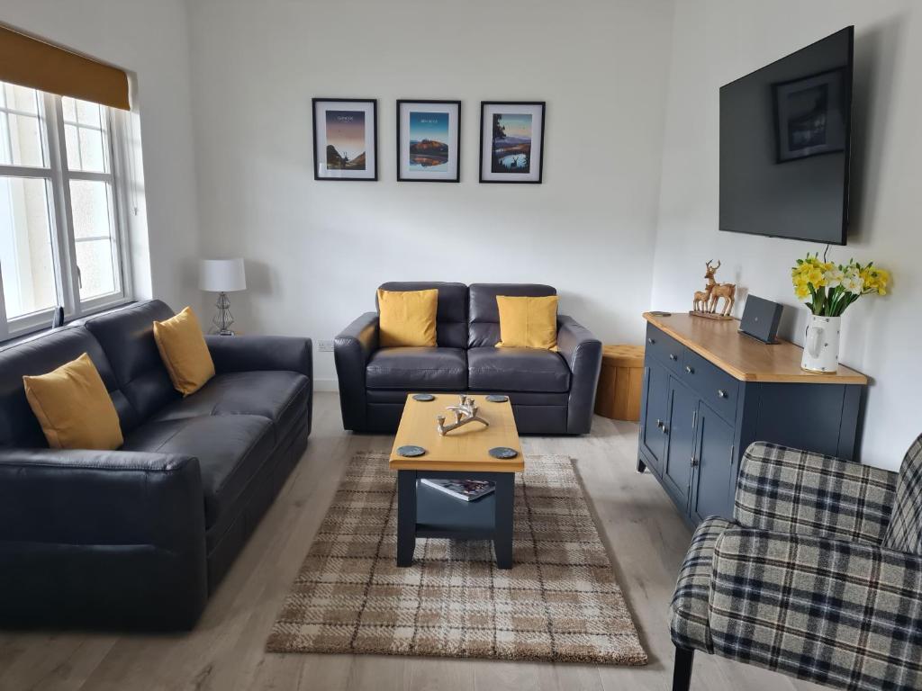 a living room with a couch and a table at 1 Golf Mews in Ballater