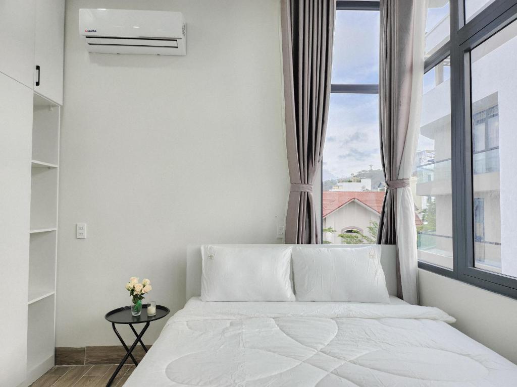 a bedroom with a white bed and a window at An Home - Phòng đơn ngay bãi sau Vũng Tàu in Vung Tau