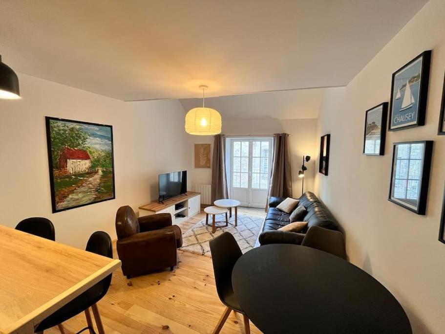 uma sala de estar com um sofá e uma mesa em Appartement à Valognes : Entre Terre et Mer em Valognes