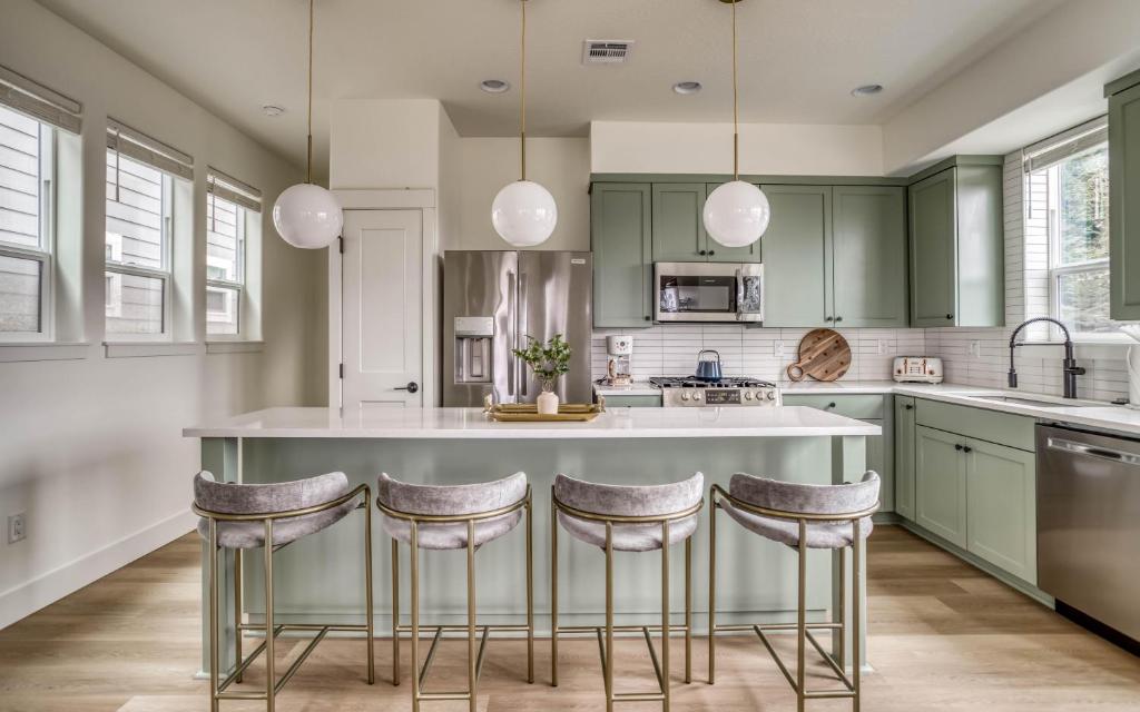 a kitchen with green cabinets and a large island with bar stools at Organic by Nature in Depoe Bay