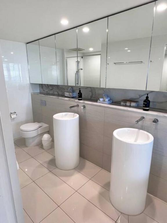 a white bathroom with two sinks and a toilet at Oracle 11th floor Tower 1 - GC Getaways in Gold Coast