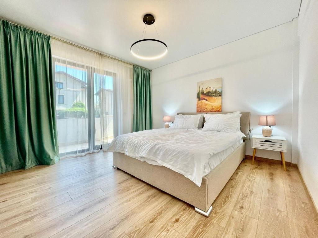 a bedroom with a bed and a large window at Residence Odaile #1 in Otopeni