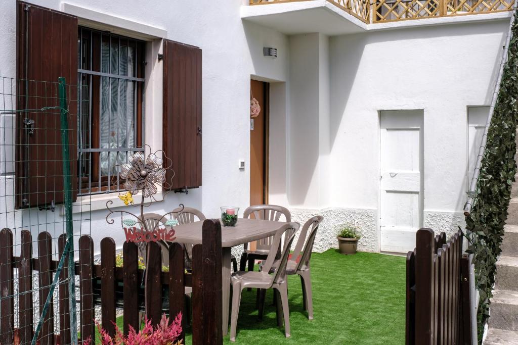 un patio con mesa y sillas en el césped en Gardaland Holiday Home*****, en Castelnuovo del Garda