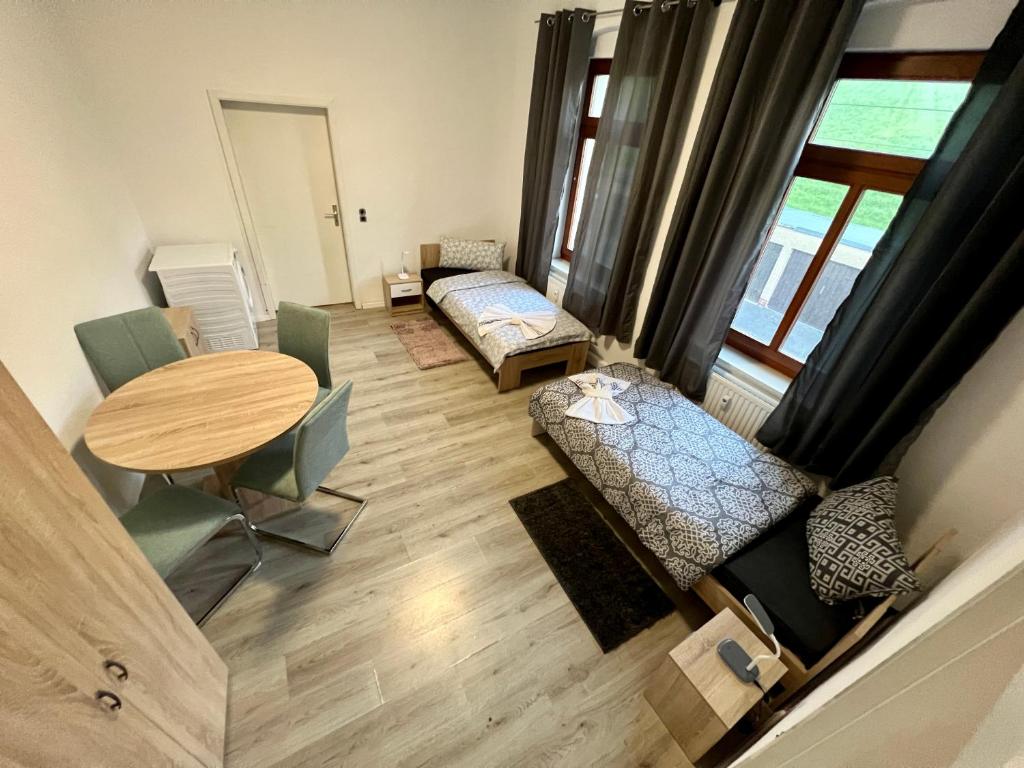 einen Blick über ein Zimmer mit einem Tisch und einem Schlafzimmer in der Unterkunft Kosta's Monteur- und Ferienwohnungen in Crimmitschau
