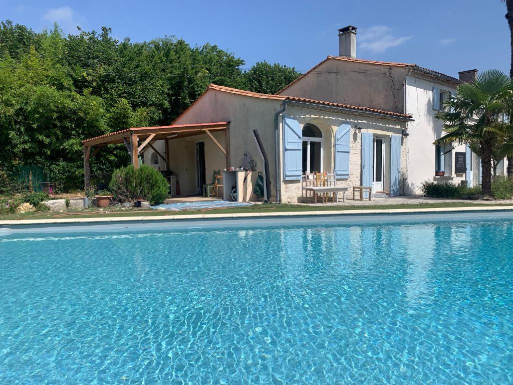 una casa y una piscina frente a una casa en Maison d'Hôtes - L'Hôthentique, en Gaillan-en-Médoc
